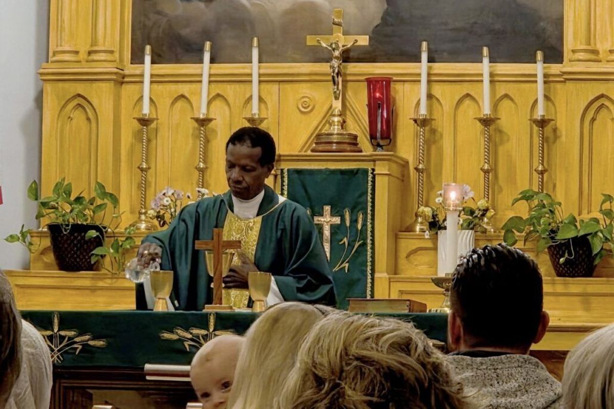 The Rev. Sipho Mathabela, who says one of his favorite duties of being a Catholic priest is celebrating Mass, consecrates bread and wine into the body and blood of Christ at the altar for Communion during a recent service.  (Lisa Ormond/FāVS News)