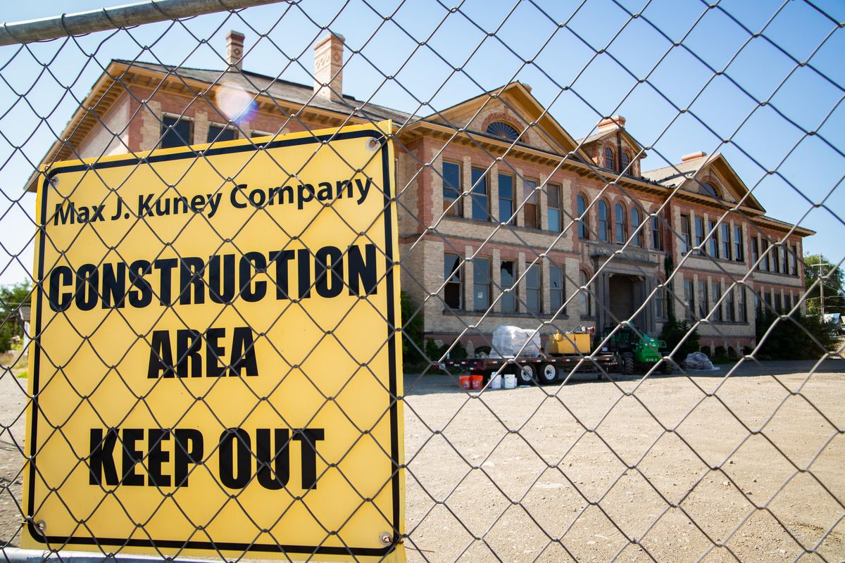 Formerly the McKinley School, the building from 1902 is seen behind chainlink fences at 117 N. Napa Street on July 31, 2019. This is one of several dormant properties owned by Rob Brewster. (Libby Kamrowski / The Spokesman-Review)