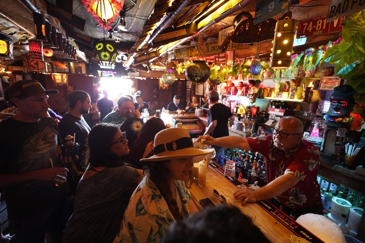 Patrons enjoy cold tropical cocktails in the tiny interior of the Tiki-Ti bar on July 7 as it reopens on Sunset Boulevard in Los Angeles.  (Damian Dovarganes)