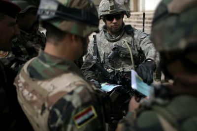 In this photo taken Friday, a U.S. Army soldier  briefs his Iraqi army colleagues while on patrol in east Baghdad.  (Associated Press / The Spokesman-Review)