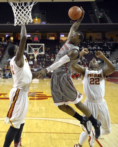 Mike Ladd, center, and his Cougars teammates endured tough loss at USC. (Associated Press)