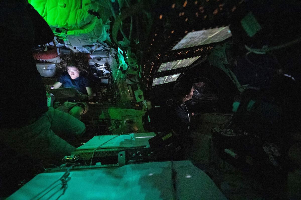 Astronaut Christina Koch sits illuminated by a screen inside the darkened Orion spacecraft on Friday, the third day of the agency’s Artemis II mission. (NASA)