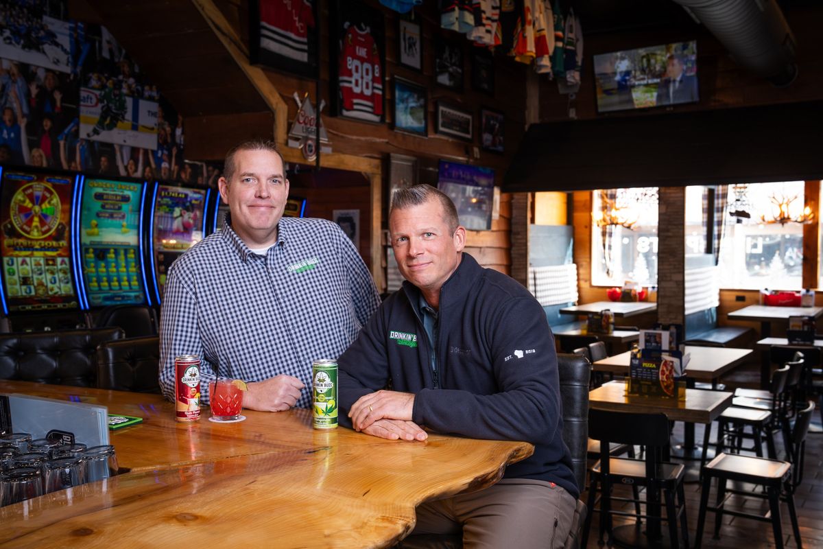 Justin Hopf, left, and Matt Swanson with cans of Drinkin’ Buds, the nonalcoholic THC-infused beverage brand they co-own, at a bar on Thursday in Fond du Lac, Wisconsin. (New York Times )
