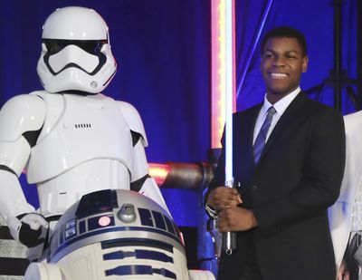 Actor John Boyega, right, poses with Star Wars characters during the Japan Premiere of their latest film 