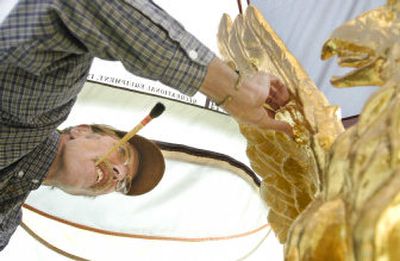 
Michael Kobold, 53, a Boise artisan who's worked since June 1 perched 208 feet atop the Idaho State Capitol, meticulously gilds the statue of an eagle perched on the Statehouse Tuesday. 
 (Associated Press / The Spokesman-Review)