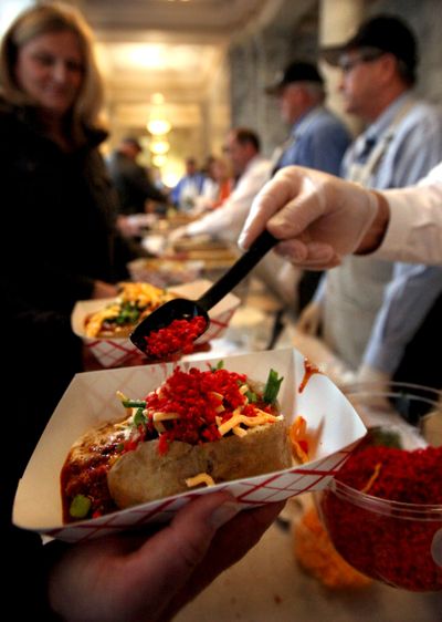 Capitol idea: Toppings are placed on a potato in a lunch line during Potato Day on Tuesday at the Capitol in Olympia. Sponsored by the Washington State Potato Commission, an estimated 2,000 potatoes were served as the organization feted the Classic Russet, a spud that was bred from a 1995 research collaboration of Washington State and Oregon State universities, the University of Idaho and the USDA. (Associated Press)