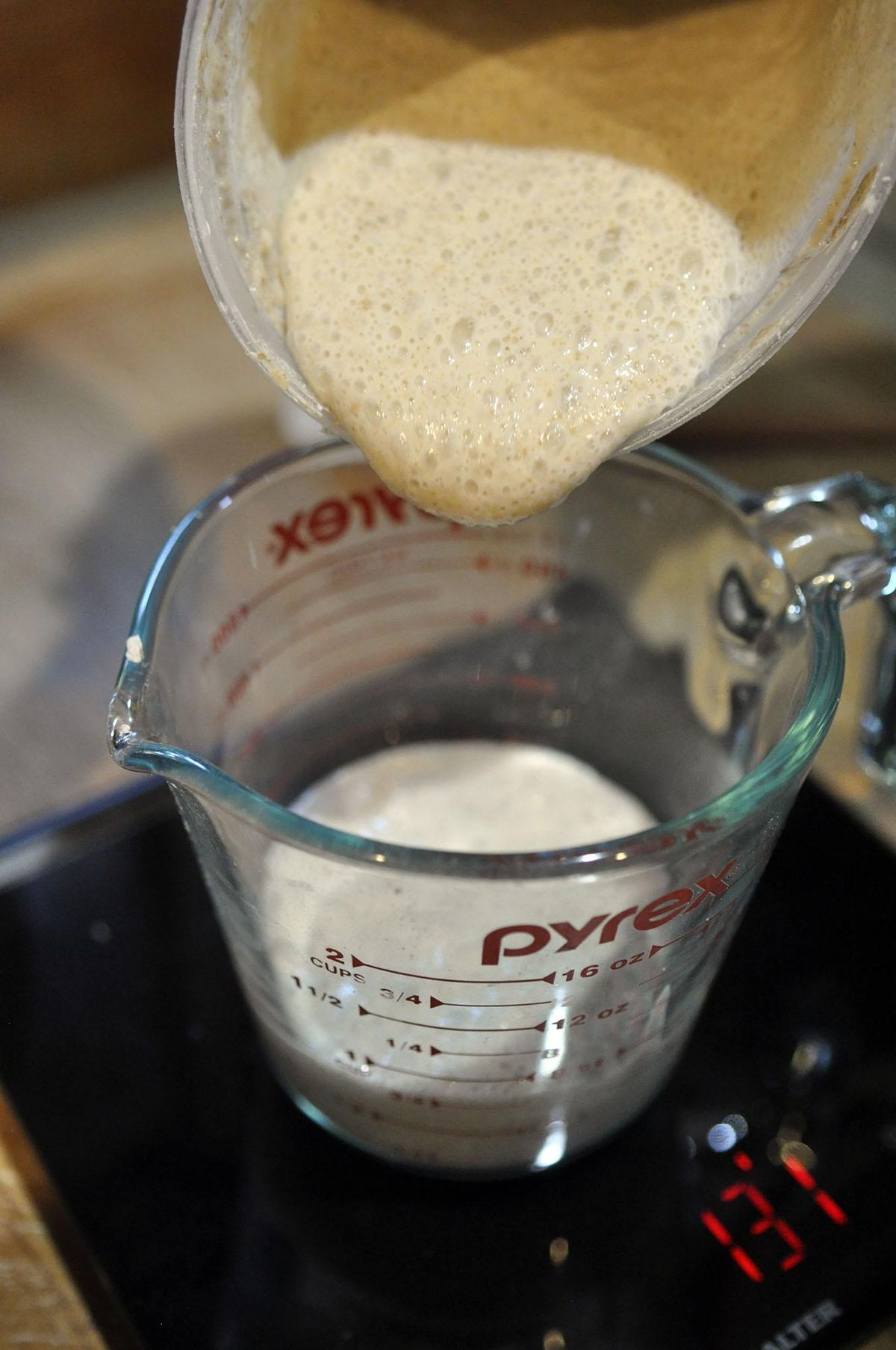 Shawn Vestal measures and weighs sourdough starter in his kitchen Friday afternoon. (Adriana Janovich / The Spokesman-Review)