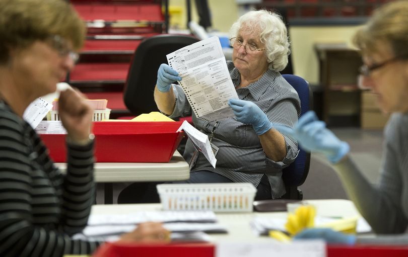 Connie Klien, center, Marsha Plewman, left, and Bev Hannibal open and check ballots Thursday at the Spokane County Elections Office. (Dan Pelle)