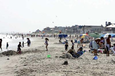 
People relax near houses that abut a broad section of Rockaway Beach in New York. Hurricane Katrina may have made landfall on the Gulf Coast, but its impact is being felt hundreds of miles away, as insurers scramble to insulate themselves from future catastrophes. 
 (Associated Press / The Spokesman-Review)