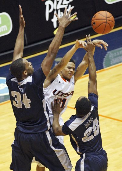 UTSA’s Michael Hall III, center, passes between Utah State’s Kyisean Reed, left, and TeNale Roland during first-half action on Saturday. (Associated Press)