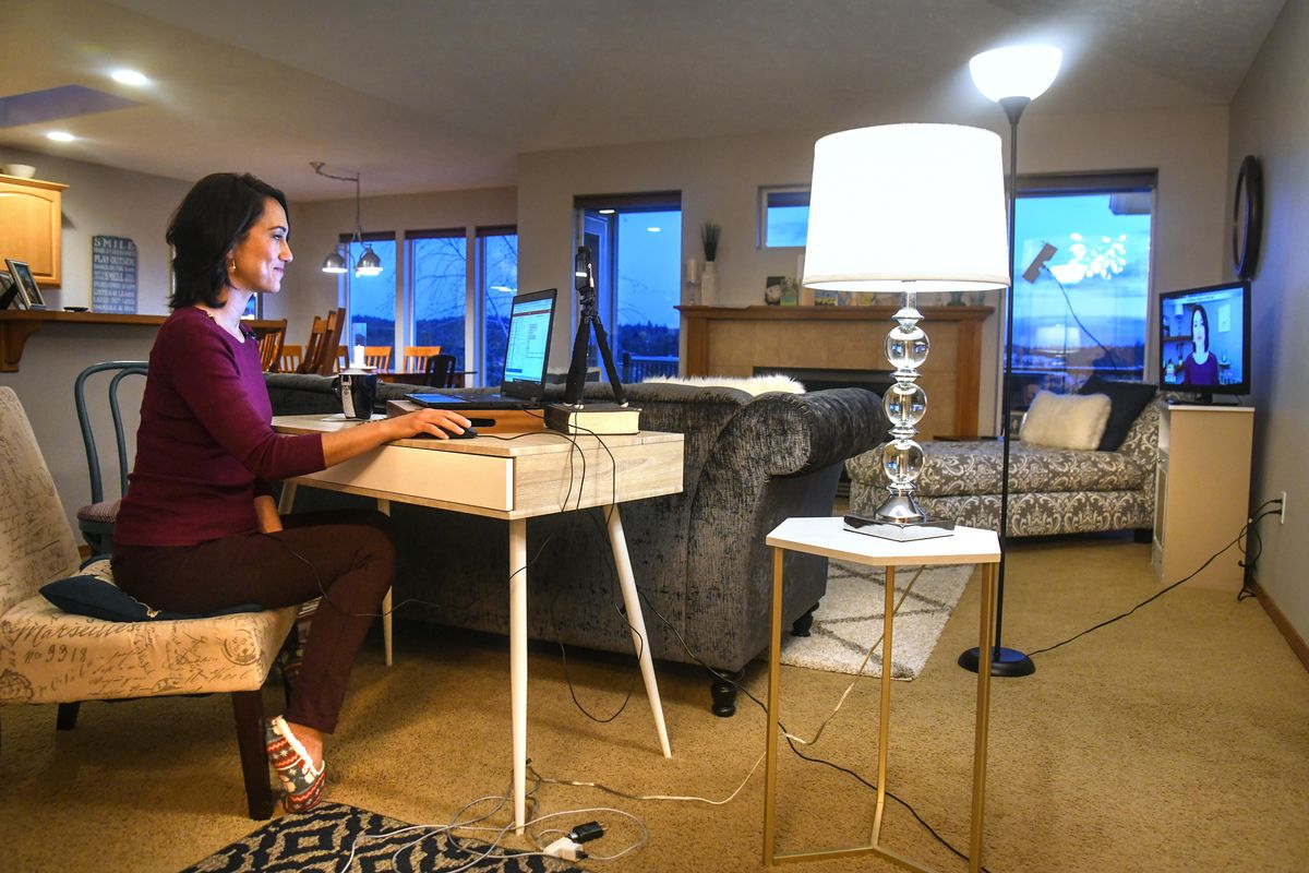 Wearing her slippers, Kalae Chock anchors the KHQ Wake Up Show from her living room, 6 a.m. Thursday, April 2, 2020. She uses a cell phone on her desk to transmit her image and a TV at far right to monitor the broadcast. (Dan Pelle / The Spokesman-Review)