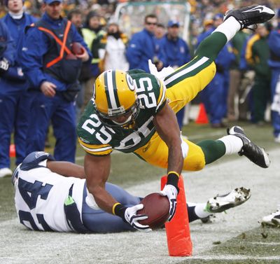 Green Bay’s Ryan Grant dives past Seattle’s Deon Grant for a touchdown in the first quarter. (Associated Press)