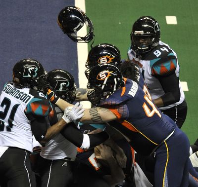 A Spokane Shock helmet flies from the head of QB Kyle Rowley as he attempts to sneak in to the endzone against the Arizona Rattlers, April 30, 2011, in the Spokane Arena. (Dan Pelle / The Spokesman-Review)