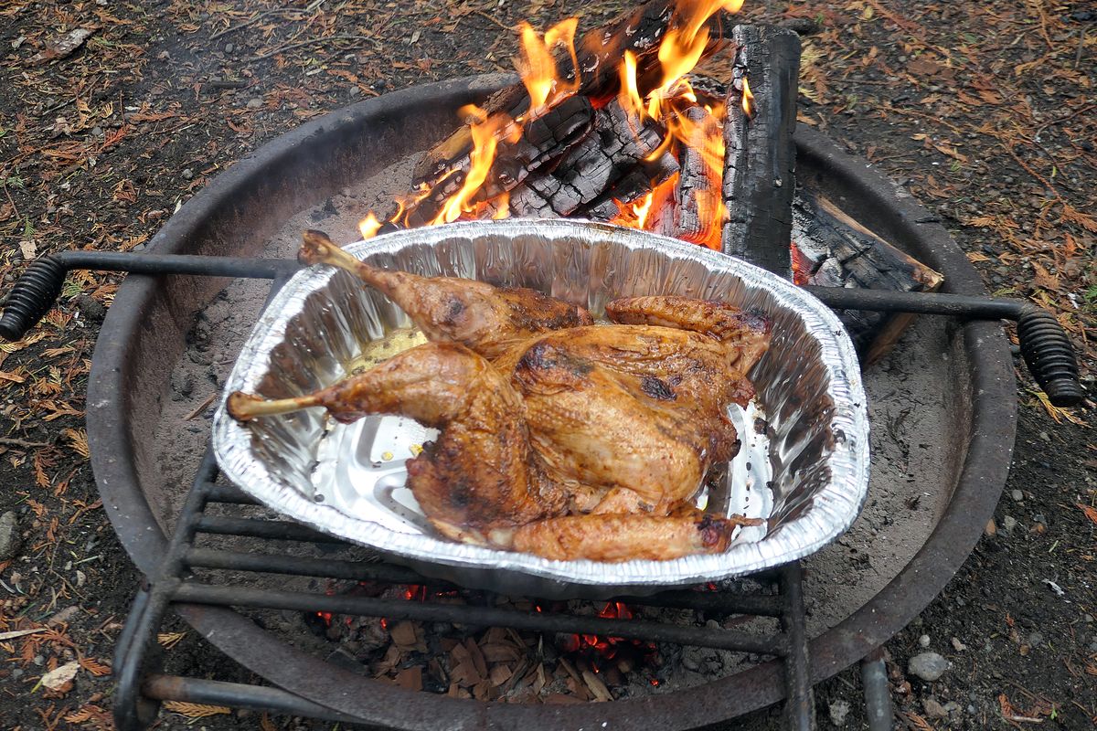 Roast turkey is warmed up over the campfire at Deception Pass State Park. (John Nelson)