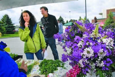 
Jennifer Hall and Eric Rau promote the Slow Food movement by handing out information pamphlets, below, to merchants at the Liberty Lake Farmers' Market. 
 (Dan Pelle / The Spokesman-Review)