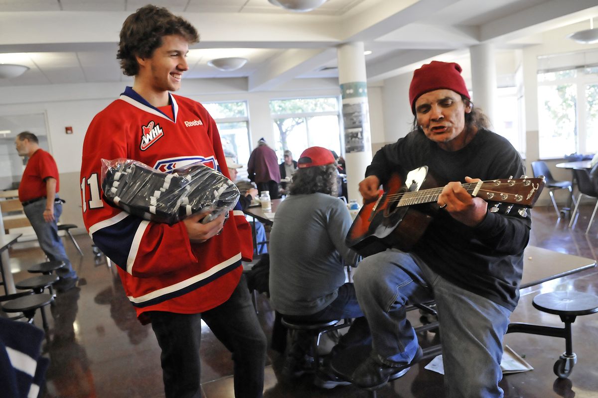 Liam Stewart, visiting the House of Charity on Tuesday with his Chiefs teammates, listens to an improvised song by Jefferson Wes about the team winning this year’s Memorial Cup. Liam is the son of pop star Rod Stewart and model Rachel Hunter. (Dan Pelle)