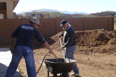 Steve Ludlum, left, and friend Richard Gullick  clean up the backyard and finish the electric and plumbing for the Ludlum’s pool in Arizona. The contractor  hired to build the pool  went bankrupt midway through the job. (Associated Press / The Spokesman-Review)