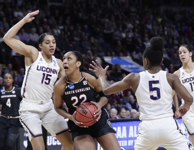 South Carolina's A'ja Wilson (22) drives past Connecticut's Gabby Williams (15) and Crystal Dangerfield (5) during Monday’s regional final. Wilson was named to the AP All-American team for a third time. (Frank Franklin II / Associated Press)