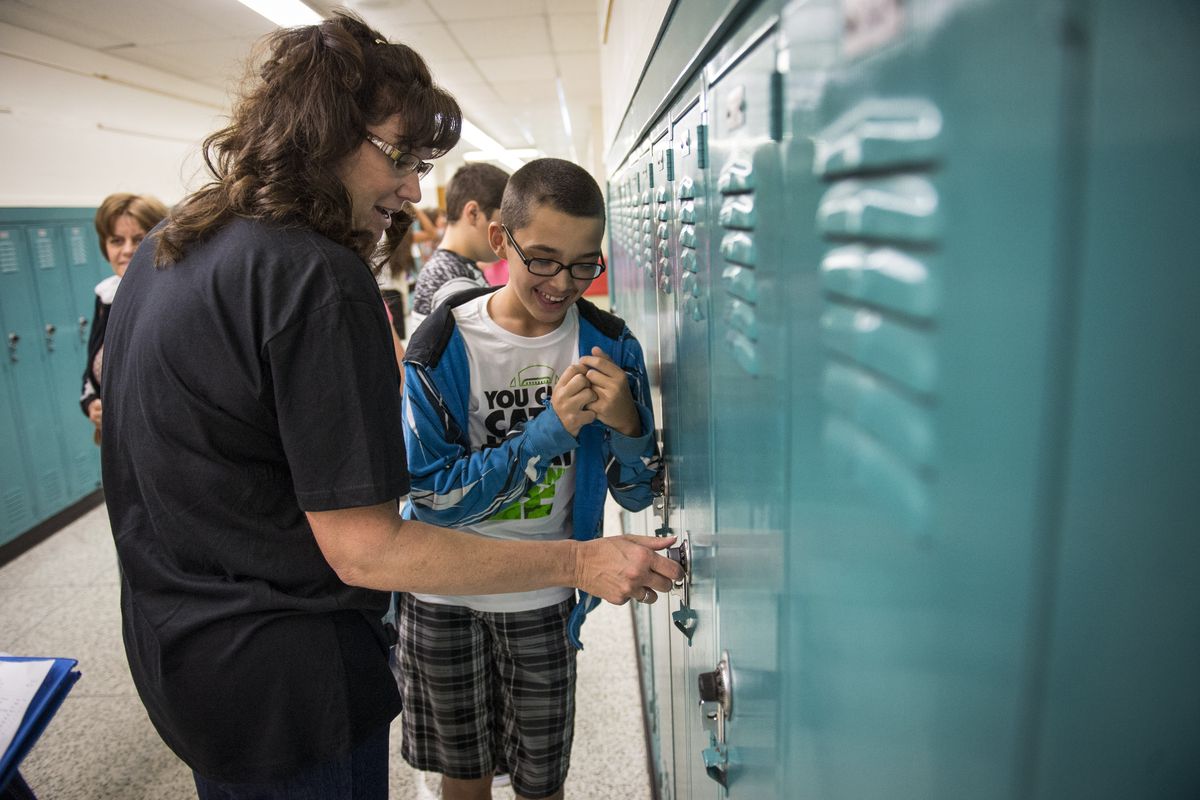 East Valley Middle School teacher Jennifer Irwin helps seventh grader Devon Low, 12, open his locker on the first day of school Wednesday. This is also the first day East Valley Middle School is open as a middle school since the district reversed its K-8 system. (Colin Mulvany)