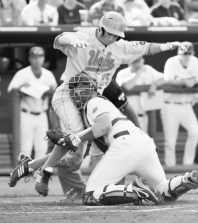 UCLA's Beau Amaral is tagged out at home by Florida’s Mike Zunino in the first inning of their College World Series game.  (Associated Press)