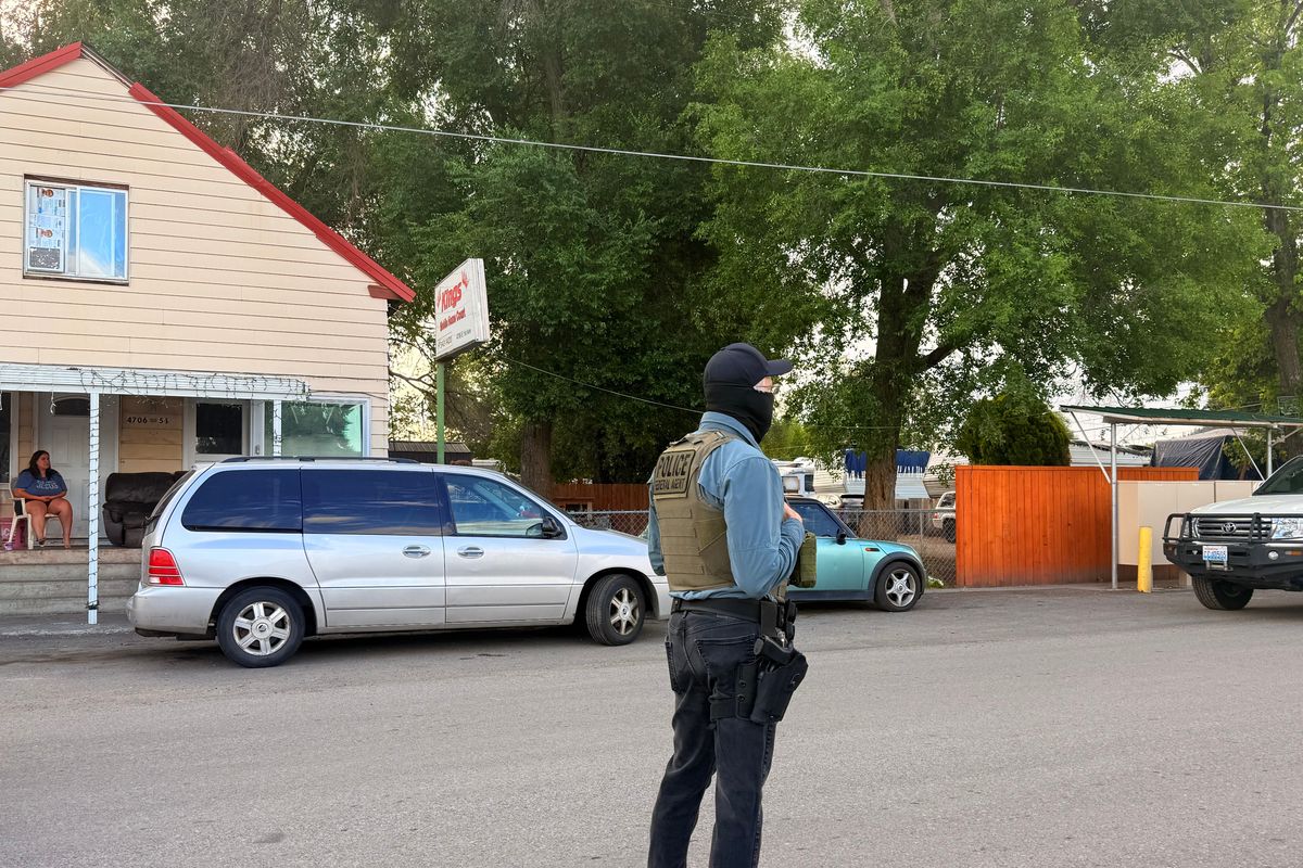 An unidentified federal agent in Spokane Valley stands to block the road during a search on June 4. (Alexandra Duggan / The Spokesman-Review)