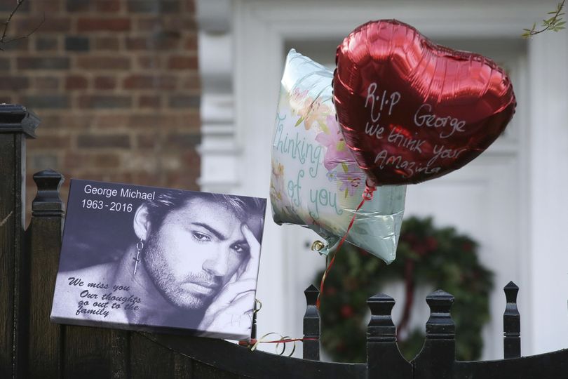 Tributes are left on the gate outside the home of British musician George Michael in London on Monday, Dec. 26, 2016. (Tim Ireland / Associated Press)