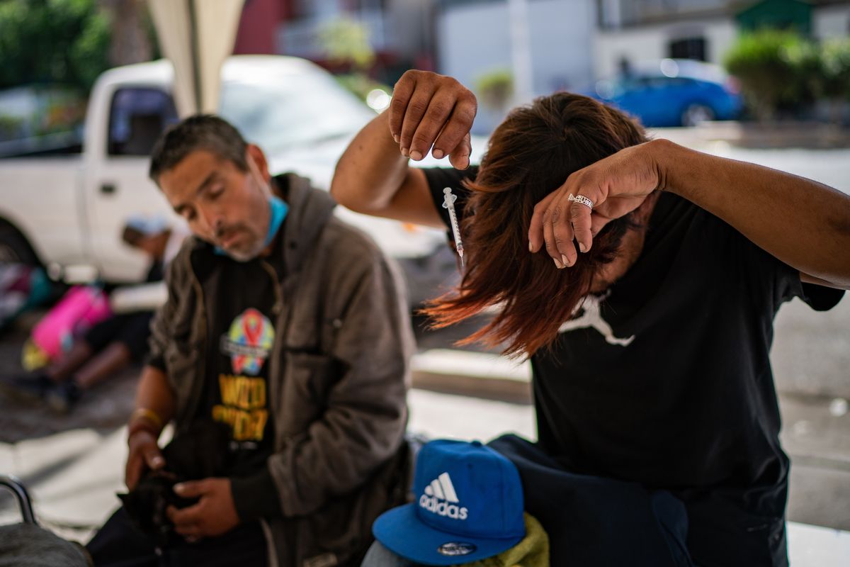 Two men in Tijuana are overtaken by the effects of fentanyl right after injecting it.    (Salwan Georges/The Washington Post)