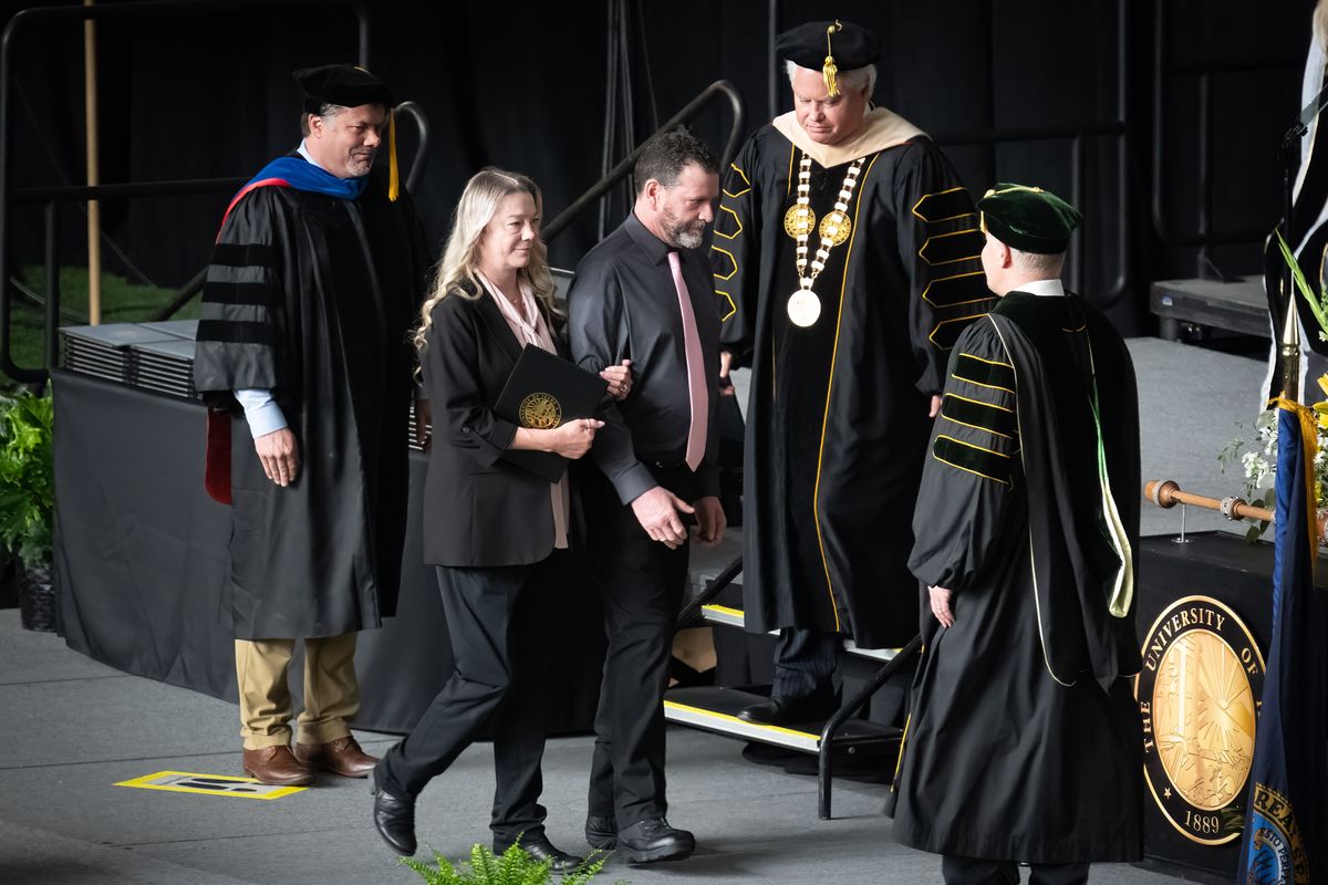 After receiving their daughter Madison Mogen’s posthumous bachelor’s degree in marketing, mother Karen Laramie and stepdad Scott Laramie walk the stage during Saturday’s University of Idaho commencement ceremony held in the Kibbie Dome in Moscow, Idaho.  (COLIN MULVANY/THE SPOKESMAN-REVIEW)