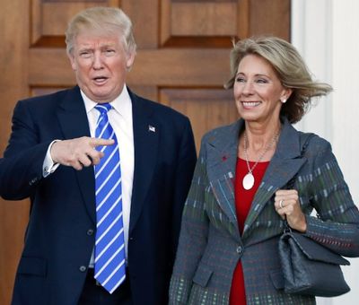 In this Nov. 19, 2016 file photo, President-elect Donald Trump, left, and Betsy DeVos, right, pose for photographs at Trump National Golf Club Bedminster's clubhouse in Bedminster, N.J. (AP Photo/Carolyn Kaster, File)