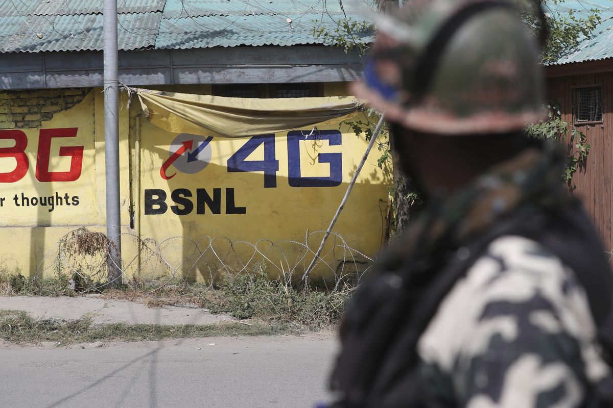 In this Thursday, Sept. 5, 2019 photo, an Indian paramilitary soldier keeps guard outside the main telephone exchange building in Srinagar, Indian controlled Kashmir. India ended an 18-month-long ban on high speed internet services on mobile devices in disputed Kashmir, where opposition to New Delhi has deepened after it revoked the region