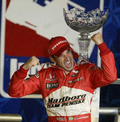 
Helio Castroneves celebrates in victory lane after winning IRL race. 
 (Associated Press / The Spokesman-Review)