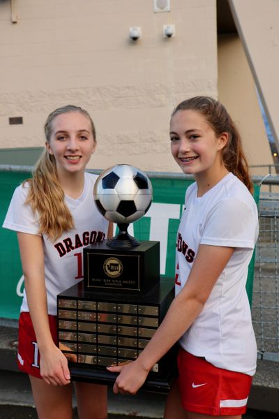 St. George’s girls soccer players Abby Jones, left, and Maddy Christiansen hold the 2016 state championship trophy. (Bob Jones / Courtesy)