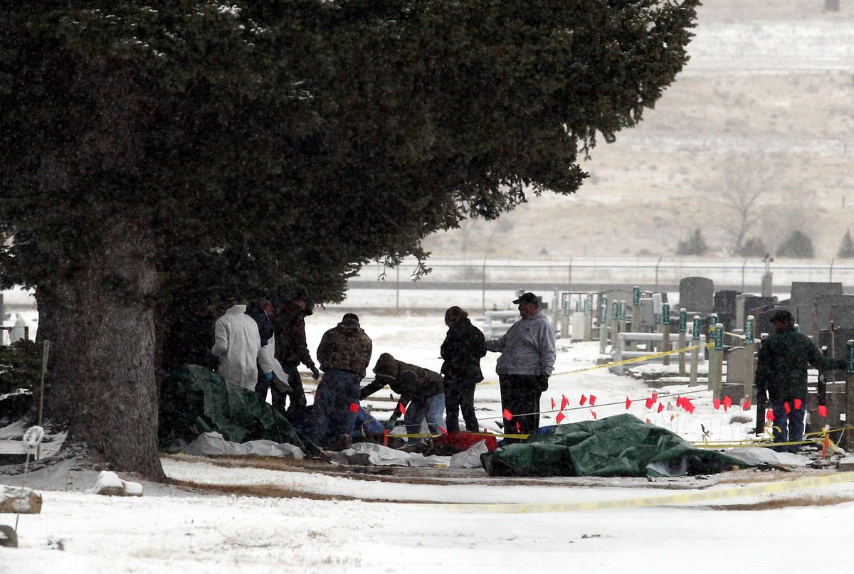 National Transportation Safety Board investigators and local police and sheriff’s deputies search the scene Monday of a fatal plane crash near the Butte airport. The single-engine turboprop plane nose-dived into the cemetery.Associated Press photos (Associated Press photos / The Spokesman-Review)