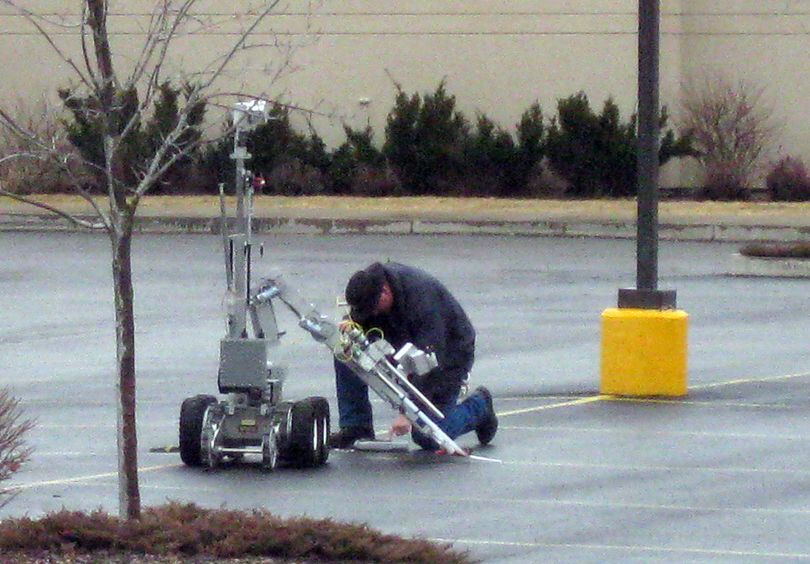 A member of the bomb squad approaches a suspicious device Saturday, Jan. 29, 2011 outside the Kootenai County Sheriff's Office in Coeur d'Alene after a robot was used to take a closer look.  The device, apparently a cell phone, a battery and a road flare, was not an explosive device. (Carolyn Lamberson / The Spokesman-Review)