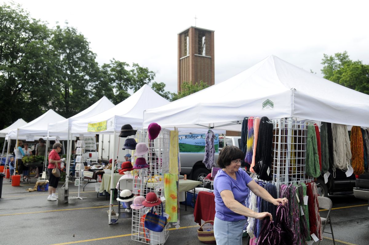 Joyce Thomas checks on her inventory of fiber, handmade hats and scarfs at the Millwood Farmers Market on Wednesday in the parking lot of Millwood Presbyterian Church. The church will pay $700 in taxes on its parking lot so the market can continue. (Jesse Tinsley / The Spokesman-Review)