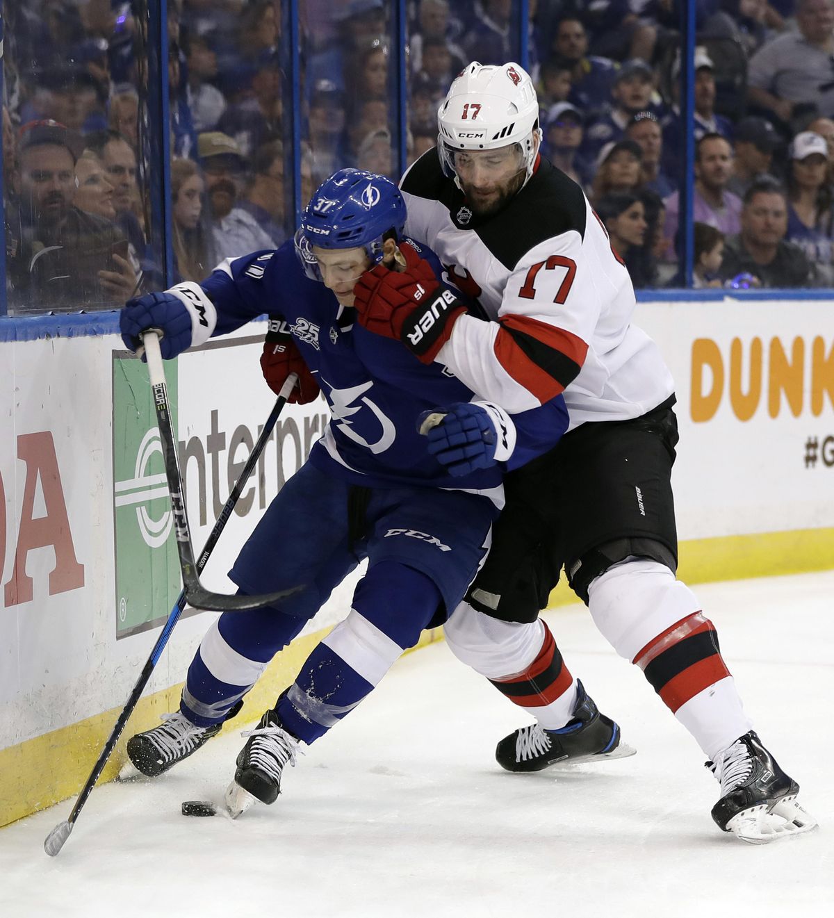 New Jersey Devils left wing Patrick Maroon (17) forces Tampa Bay Lightning center Yanni Gourde into the dasher during the first period of Game 2 of an NHL first-round hockey playoff series Saturday, April 14, 2018, in Tampa, Fla. (Chris O'Meara / Associated Press)