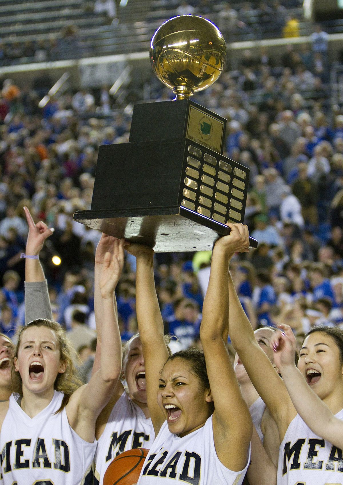 Mead’s Jade Redmon, middle, holds up the State 4A championship trophy with her teammates. (Patrick Hagerty)