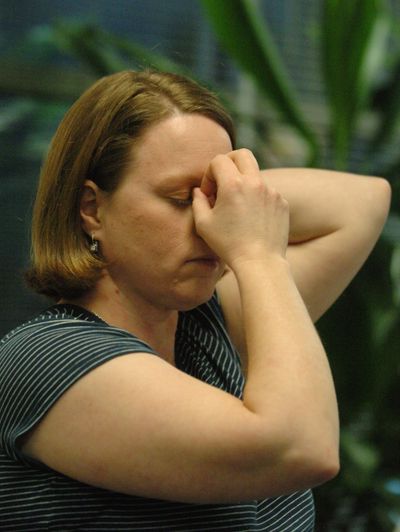Elizabeth Karkosky shows a Tapas acupressure technique, with one hand cradling the back of her neck and the thumb and ring finger of the other hand in the corners of her eyes and the middle finger in the center at the “third eye” during a therapy session in Portland. A $2 million government study will test whether this acupressure technique can prevent dieters from regaining weight.  (Associated Press / The Spokesman-Review)