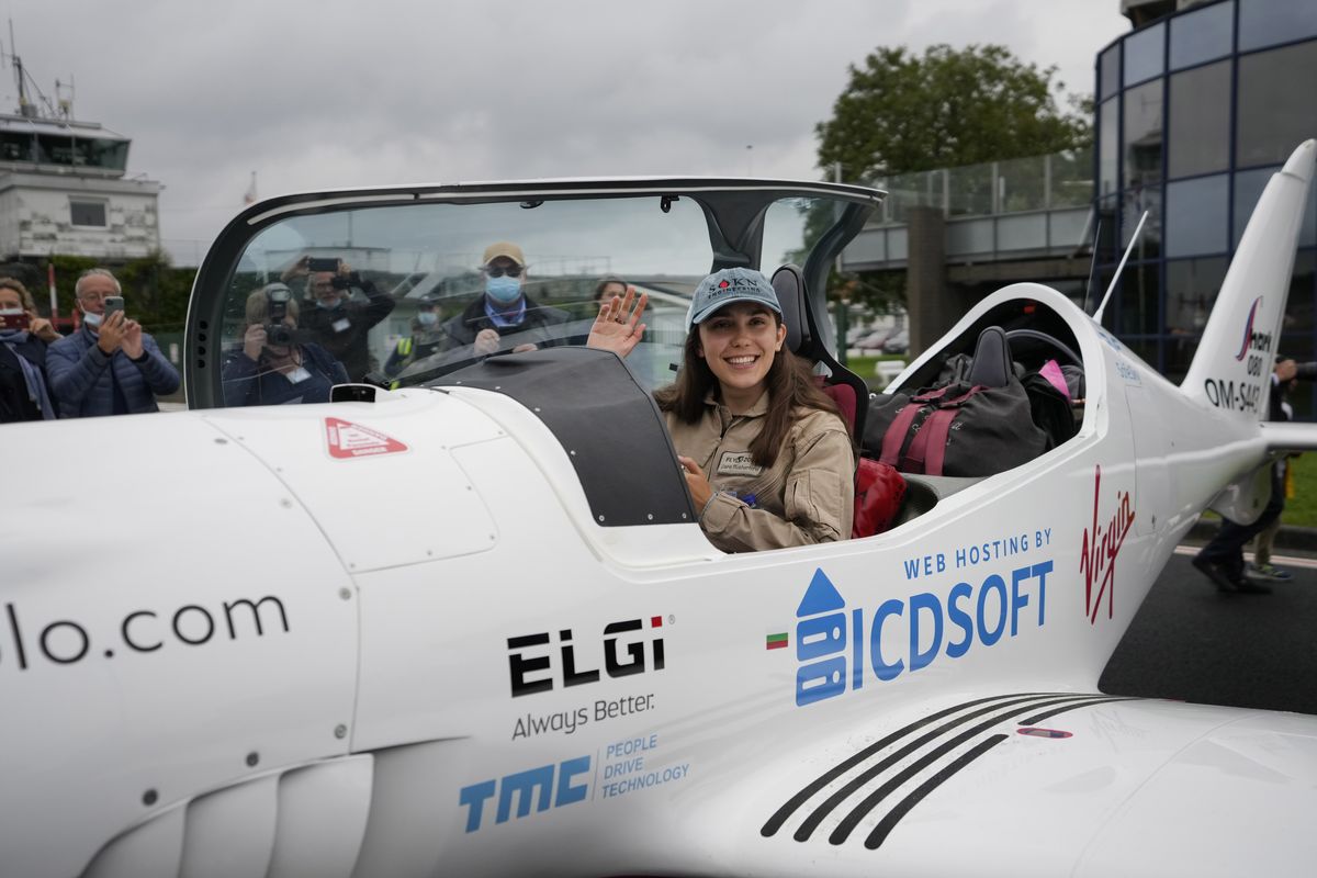 Belgian-British teenager Zara Rutherford waves from her Shark Ultralight airplane prior to take off at the Kortrijk-Wevelgem airfield in Wevelgem, Belgium, Wednesday, Aug. 18, 2021. A Belgian-British teenager took to the skies Wednesday in her quest to become the youngest woman to fly around the world solo. Nineteen-year-old Zara Rutherford took off from an airstrip in Wevelgem, Belgium, in an ultralight plane looking to break the record set by American aviator Shaesta Waiz, who set the world benchmark at age 30 in 2017.  (Virginia Mayo)
