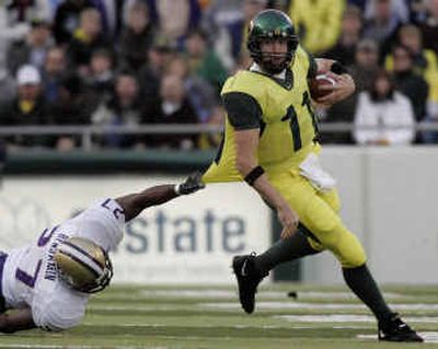 
Oregon quarterback Kellen Clemens tries to break away from Washington's Evan Benjamin (27) during the first quarter.
 (Associated Press / The Spokesman-Review)