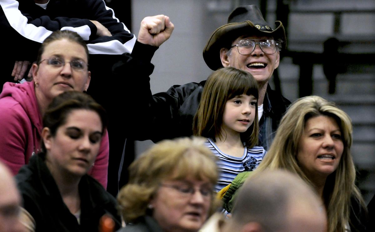 Chuck Young, 71, holds his great-granddaughter Destiny, 8, while cheering for his great-grandson Brayden, 6, at the Cub Scouts’ Pinewood Derby on March 31 in Coeur d’Alene. Young and his wife, Shirley, are raising four of their great-grandchildren. (Kathy Plonka / The Spokesman-Review)