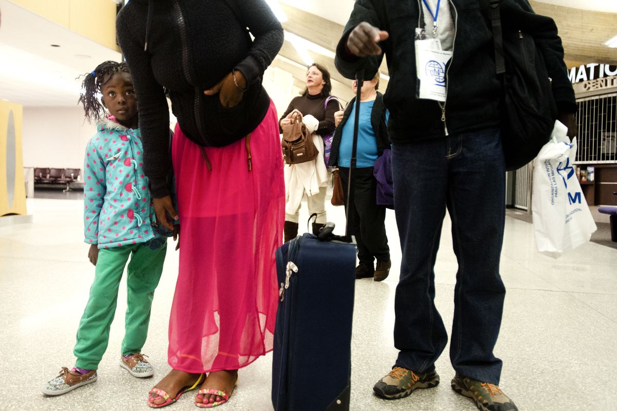 Congolese refugee Dakie Tshilobo stands wide-eyed with her mother, Jolie Ngenda, and father, Patrick Kazadi, after landing at Spokane International Airport late Feb. 7. (Tyler Tjomsland)