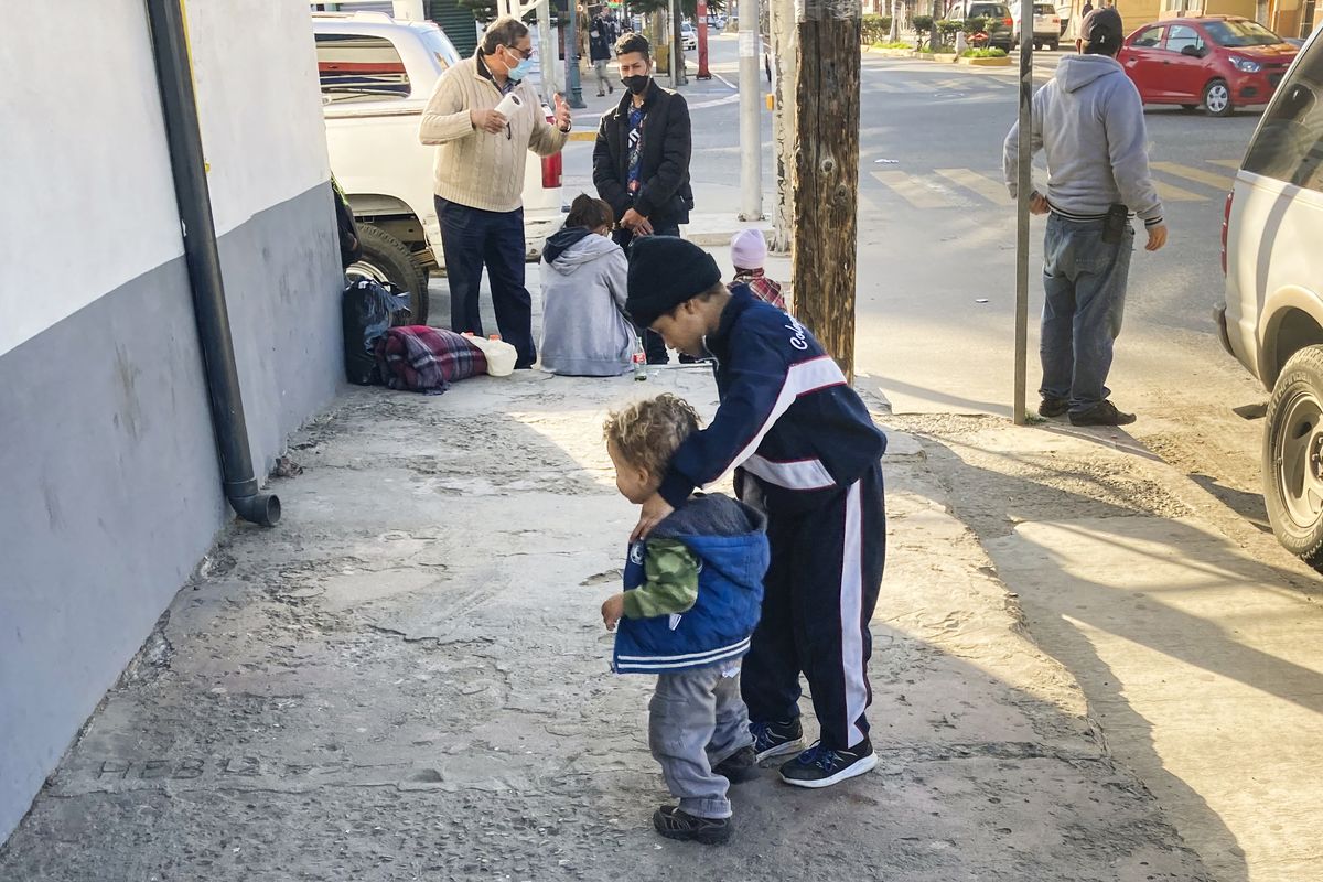 Honduran boys whose family wants to seek asylum in the U.S., play on the sidewalk in Tijuana, Mexico, Monday, Feb. 8, 2021. Thousands of people are waiting to claim asylum and more come each day, falsely believing they will be able to enter the U.S. now that former President Donald Trump is out of office. While President Joe Biden has taken some major steps in his first weeks in office to reverse Trump