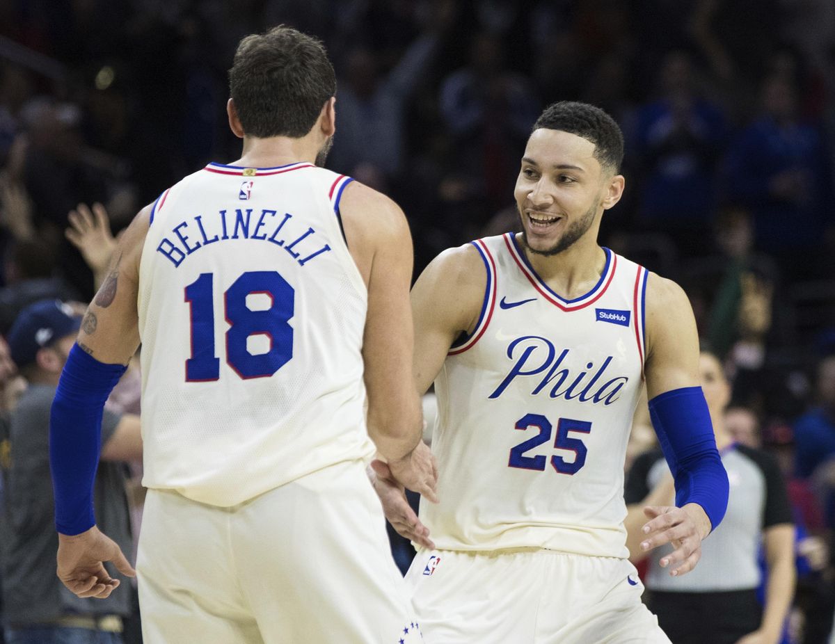 In this April 6, 2018 file photo, Philadelphia 76ers’ Ben Simmons, right, of Australia, reacts to his assist on a three-point basket by Marco Belinelli, left, of Italy, during the first half of an NBA basketball game against the Cleveland Cavaliers in Philadelphia. The Sixers set a team record with their 15th consecutive victory, holding off the Atlanta Hawks 121-113 on Tuesday night in the penultimate game of the regular season. (Chris Szagola / Associated Press)