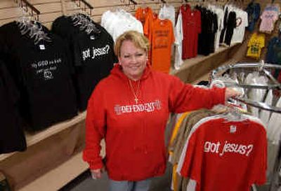 
Lori Devins poses with some of the T-shirts for sale in her Extreme Christian Clothing store in Lawrence, Kan. 
 (Associated Press / The Spokesman-Review)