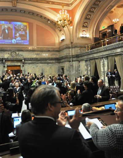 OLYMPIA -- Sine die adjournment ceremony in the Senate, with Lt. Gov. Brad Owen and Sen. Margarita Prentice, D-Renton, in the foreground at the rostrum, senators, staff and lobbyists on the floor and the video from the House and Senate ceremonies projected on the wall. (Jim Camden)
