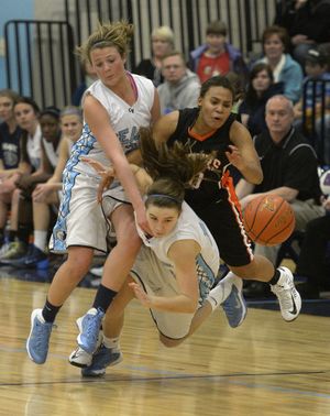 Central Valley's Kristin Everhart, left, Courtney Carolan, center and Lewis and Clark's Hannah Hendricksen collide over a loose ball in the second half, Friday, Jan. 3, 2014, at Central Valley High School. (Colin Mulvany / The Spokesman-Review)