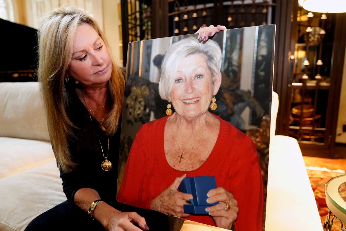 M.J. Jennings looks at a photo of her mother Leah Corken while sitting at her home in Dallas, Wednesday, Nov. 3, 2021. Corken was one of 18 women in the Dallas area that Billy Chemirmir is charged with capital murder and he is suspected in several more deaths. Most of the deaths happened at upscale independent living communities for older people, where Chemirmir has been accused of forcing his way into apartments or posing as a handyman, and in a couple instances was even caught trespassing.  (LM Otero)