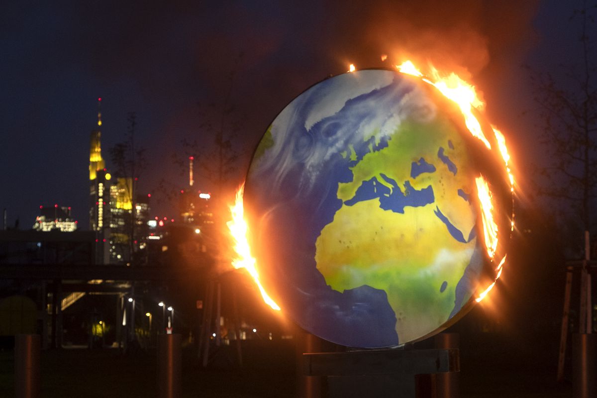 A makeshift globe burns in front of the European Central Bank in Frankfurt, Germany, Wednesday, Oct. 21, 2020. Activists of the so-called "KoalaKollektiv", an organization asking for climate justice, protested with the burning of the globe against the ECB
