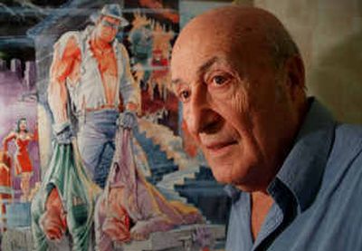 
Will Eisner stands next to a poster of 